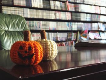 Close-up of halloween decoration on table against bookshelves