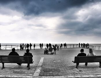 People in sea against sky