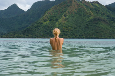 Rear view of shirtless man in lake