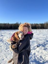 Young woman with dog on snow