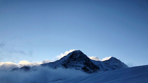 Scenic view of snowcapped mountains against blue sky