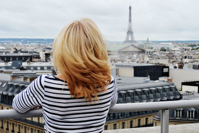 Rear view of woman standing against cityscape