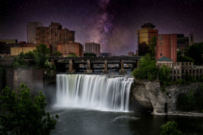 Scenic view of waterfall against sky at night