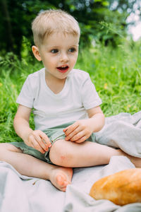 Portrait of boy sitting on field