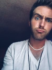 Low angle portrait of young man making face at home