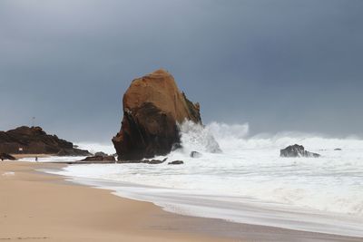 Rocks on beach against sky