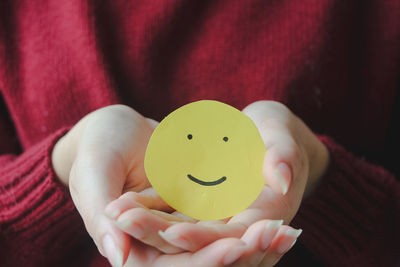 Midsection of woman holding heart shape