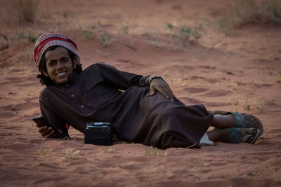 Portrait of young man sitting on land