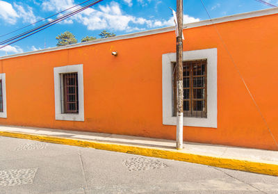 Residential building by road against orange sky