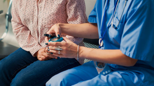Midsection of man using mobile phone while sitting on sofa