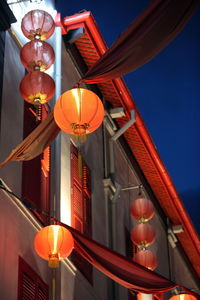 Low angle view of illuminated chinese lantern hanging outside building at night
