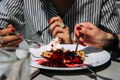 Midsection of woman holding food on table