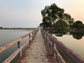 Wooden pier over lake against sky