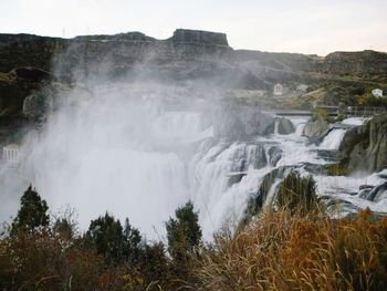 Scenic view of waterfall against sky
