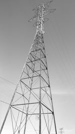 Low angle view of electricity pylon against clear sky