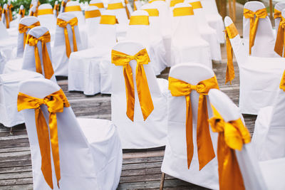 High angle view of chairs covered with white textiles on floorboard