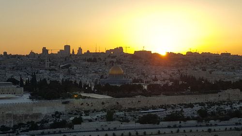 Buildings in city against sky during sunset