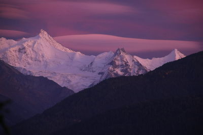 Scenic view of snowcapped mountains against sky during sunset