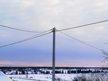 Power lines against sky during winter