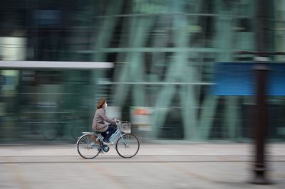 Man riding bicycle on road in city