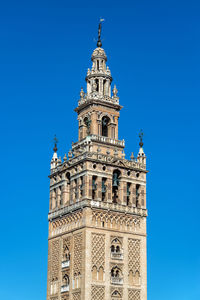 Low angle view of clock tower against blue sky