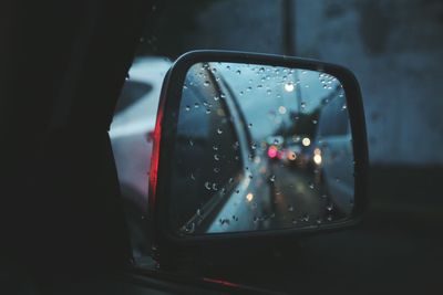 Reflection of cars on wet side-view mirror