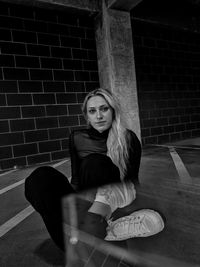 Portrait of woman sitting against wall