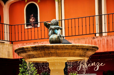 Statue of fountain against building