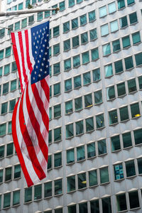 Low angle view of flag against buildings in city