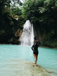 Woman standing at waterfall