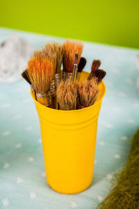 Paint brushes in the glass with green natural background