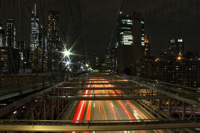 Light trails on road amidst buildings at night