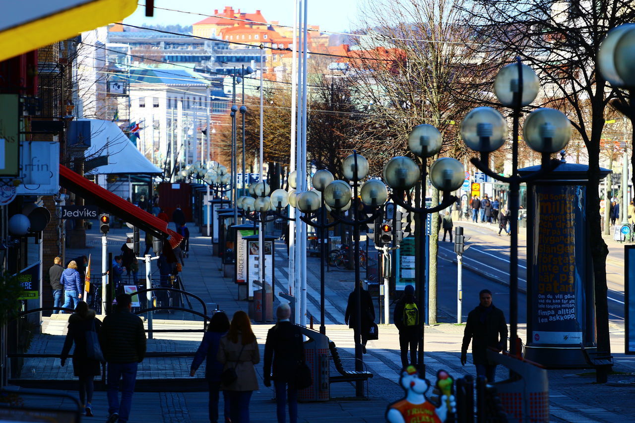 GROUP OF PEOPLE WALKING ON STREET IN CITY