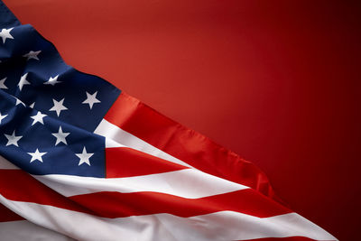 Low angle view of flag against red wall