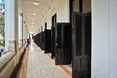 Rear view of man walking on footpath amidst buildings