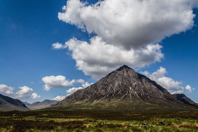 Scenic view of mountains against cloudy sky