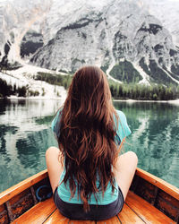 Rear view of woman in lake against mountains