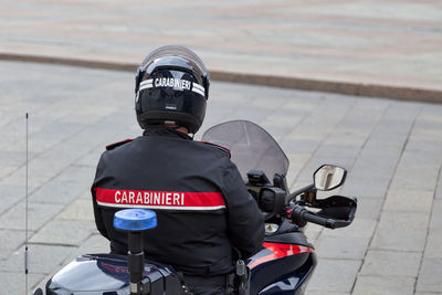 Rear view of man using smart phone in city