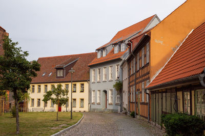 Footpath amidst buildings against sky