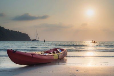 Boat in sea against sky during sunset