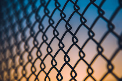 Close-up of chainlink fence against sky