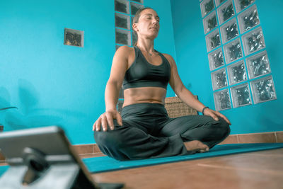 Full length of woman sitting at home