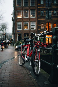 Bicycle parked on street by building in city