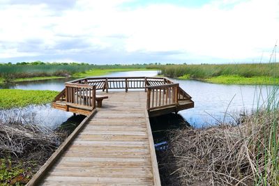 Wooden structure in lake against sky