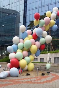 Close-up of multi colored balloons hanging on building