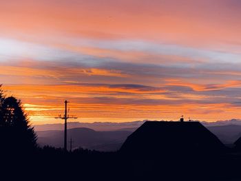 Silhouette mountain against orange sky