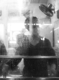 Reflection of man photographing in glass window