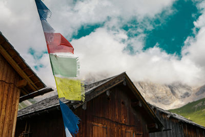 Low angle view of flags hanging on building against sky