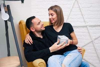 Happy couple sitting on floor