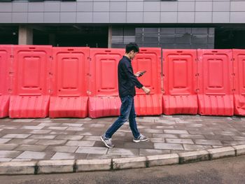 Full length of man walking on footpath